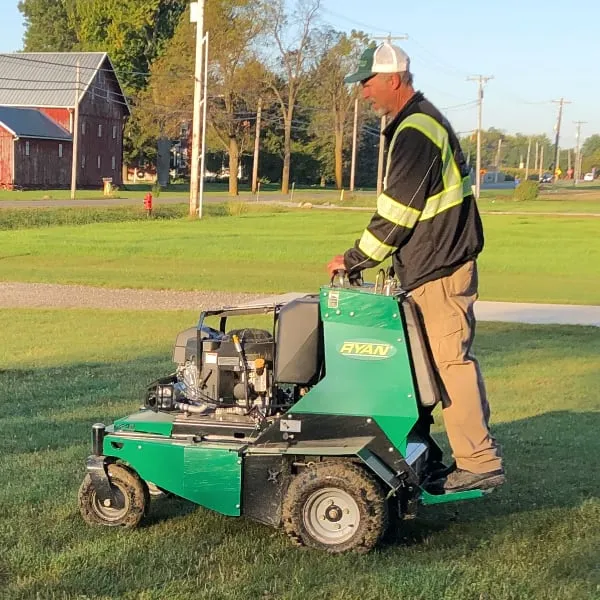 Man riding lawn equipment.